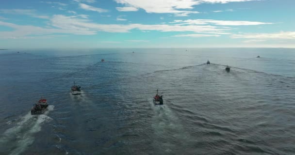 Rybářské čluny vyplouvají při západu slunce k rybám na klidném mořském povrchu v létě. Letecký pohled. — Stock video