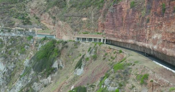 Aerial view. Chapmans Peak Drive near Cape Town, South Africa. Top view of road going through beautiful landscape. Road bending along the ocean. — Stock Video