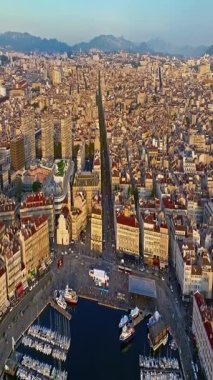 Sabah güneşinde Marsilya şehrinin havadan görünüşü. Fransız şehrinin çatıları. Bir sürü insan kıyı kasabasında geziniyor. Fransa 'nın güneyindeki Marsilya' nın insansız hava aracı görüntüsü.