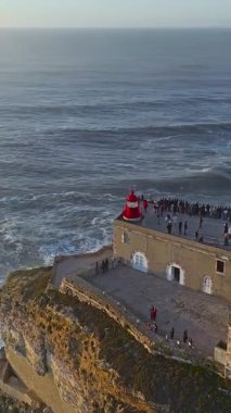  Nazare Deniz fenerinin hava manzarası. Dünyanın en büyük dalgaları çarpıcı deniz fenerinin kayalarına çarpıyor. Portekiz.