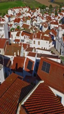  Yel değirmeni ve pitoresk çatıları olan küçük köyün havadan görünüşü, Aldatmaca, Portekiz.