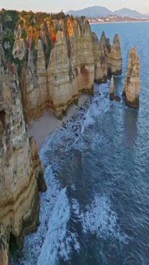  Günbatımında Ponta da Piedade, Lagos, Portekiz 'deki dramatik uçurumların ve deniz fenerinin havadan görünüşü.