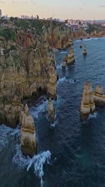  Günbatımında Ponta da Piedade, Lagos, Portekiz 'deki dramatik uçurumların ve deniz fenerinin havadan görünüşü.