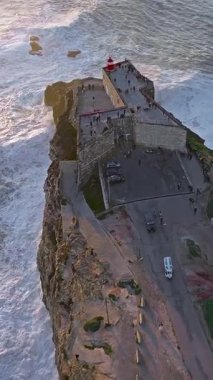  Nazare Deniz fenerinin hava manzarası. Dünyanın en büyük dalgaları çarpıcı deniz fenerinin kayalarına çarpıyor. Portekiz.