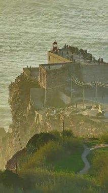  Nazare Deniz fenerinin hava manzarası. Dünyanın en büyük dalgaları çarpıcı deniz fenerinin kayalarına çarpıyor. Portekiz.