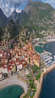  Menton, Fransa 'nın havadan görünüşü. Yazın renkli Menton kasabası, tarihi binalar ve gün batımında güzel plajlar. Tarihi kilisenin ve renkli çatıların hava görüntüleri..