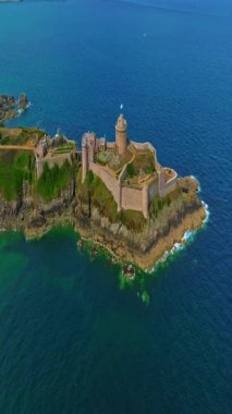 La Latte Kalesi 'nin havadan görünüşü, Cap Frehel, Brittany, Fransa' daki Chateau de la Roche Guyon kumtaşı kayalıklarında dalgaların ezdiği güneşli bir yaz gününde.