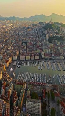 Sabah güneşinde Marsilya şehrinin havadan görünüşü. Fransız şehrinin çatıları. Bir sürü insan kıyı kasabasında geziniyor. Fransa 'nın güneyindeki Marsilya' nın insansız hava aracı görüntüsü.