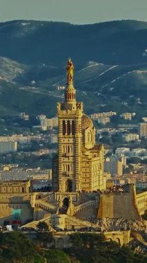  Notre Dame de la Garde 'ın ya da güney Fransa' da günbatımında Muhafız Kilisesi 'nin hava manzarası. Sıcak yaz akşamı ışığı Marsilya şehir manzarasını aydınlatıyor..