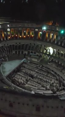  Geceleri Colosseum 'un uçan insansız hava aracını kuruyorum. Kolezyum mimari aydınlatmayla aydınlatıldı. Roma şehir merkezi, İtalya. Kolezyum ve Roma 'daki İmparatorluk Forumları.