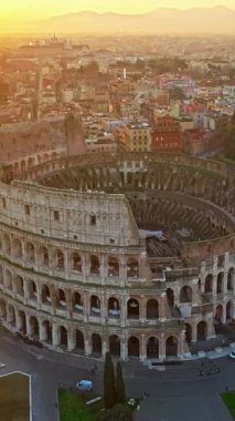  Günbatımında Colosseum 'un ikonik antik arenasının havadan görünüşü. Roma, İtalya 'nın göbeğinde Flavian amfitiyatrosu.