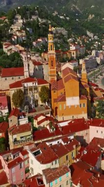  Menton, Fransa 'nın havadan görünüşü. Yazın renkli Menton kasabası, tarihi binalar ve gün batımında güzel plajlar. Tarihi kilisenin ve renkli çatıların hava görüntüleri..