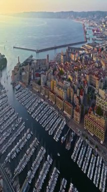 Sabah güneşinde Marsilya şehrinin havadan görünüşü. Fransız şehrinin çatıları. Bir sürü insan kıyı kasabasında geziniyor. Fransa 'nın güneyindeki Marsilya' nın insansız hava aracı görüntüsü.