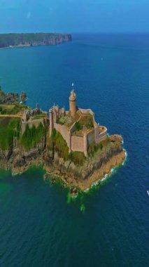  La Latte Kalesi 'nin havadan görünüşü, Cap Frehel, Brittany, Fransa' daki Chateau de la Roche Guyon kumtaşı kayalıklarında dalgaların ezdiği güneşli bir yaz gününde.