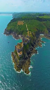  La Latte Kalesi 'nin havadan görünüşü, Cap Frehel, Brittany, Fransa' daki Chateau de la Roche Guyon kumtaşı kayalıklarında dalgaların ezdiği güneşli bir yaz gününde.