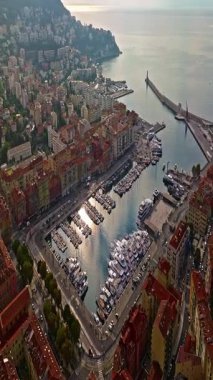  Güneşli bir günde, hareketli bir sahil yürüyüşü manzarası. Nice, Fransa 'da güzel bir manzara. Palmiye ağaçları, eski kasabadaki eski evler gök mavisi deniz ve yeşil tepeler. Fransız Rivierasında yaz.