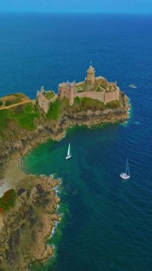  La Latte Kalesi 'nin havadan görünüşü, Cap Frehel, Brittany, Fransa' daki Chateau de la Roche Guyon kumtaşı kayalıklarında dalgaların ezdiği güneşli bir yaz gününde.