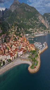  Menton, Fransa 'nın havadan görünüşü. Yazın renkli Menton kasabası, tarihi binalar ve gün batımında güzel plajlar. Tarihi kilisenin ve renkli çatıların hava görüntüleri..