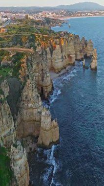  Günbatımında Ponta da Piedade, Lagos, Portekiz 'deki dramatik uçurumların ve deniz fenerinin havadan görünüşü.