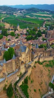 Fransa 'nın güneyindeki Carcassonne Ortaçağ şehrinin havadan görünüşü. Carcassonne tarihi kalesi gün batımında popüler turizm merkezi. Dikey video.