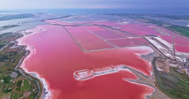 Güneşli bir günde, Fransa 'nın güneyindeki Camargue bölgesinde, pembe tuz gölü yakınlarındaki ortaçağ duvarlı Aigues-Mortes kasabasının havadan görünüşü.