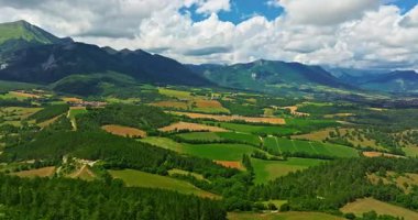 Tarlaların havadan görünüşü ve arka planda dağlar olan gökyüzündeki güneş. Fransız manzarası.