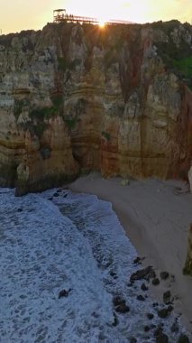 Günbatımında Ponta da Piedade, Lagos, Portekiz 'deki dramatik uçurumların ve deniz fenerinin havadan görünüşü.
