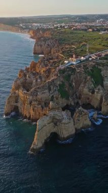 Günbatımında Ponta da Piedade, Lagos, Portekiz 'deki dramatik uçurumların ve deniz fenerinin havadan görünüşü.