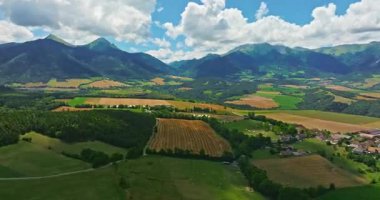 Tarlaların havadan görünüşü ve arka planda dağlar olan gökyüzündeki güneş. Fransız manzarası.