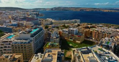 Malta adasında yüzme havuzlu turistik apartman manzarası. Adadaki konut piyasası ve turist konutlarının inşası.