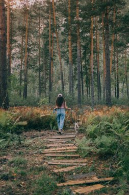 Yavru köpekli kız ormanda yürüyor.
