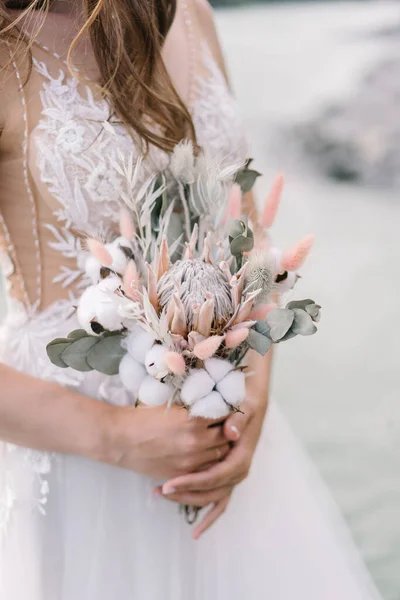 Gelin bir düğün buketi tutuyor.