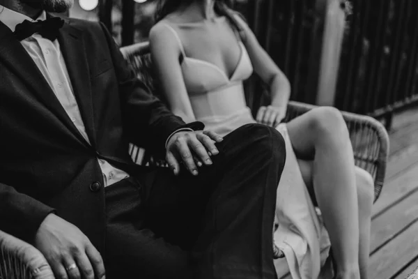 Takım elbiseli damat geline sarılıyor.