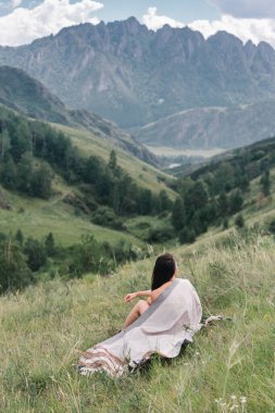 Yeşil vadide pançolu bir kız dağların arkasında