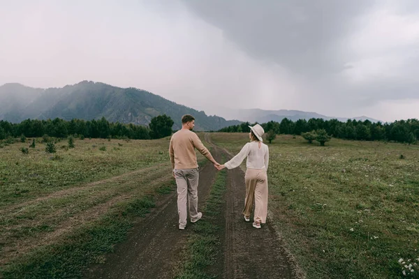 Sevgi dolu bir çift yol boyunca yürür tarlaların arasında