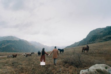 Bir çift aşık sonbaharda bir at sürüsüne gider.