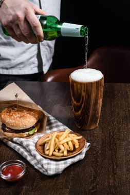 Biralı ahşap bardak ve masada servis edilen ahşap tabaklarda atıştırmalıklar.