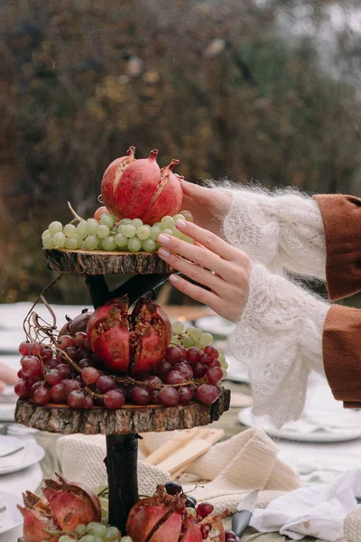 Mädchenhände Legen Herbst Granatapfel Auf Einen Teller Mit Trauben — Stockfoto