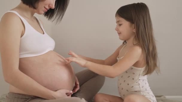 Joven Embarazada Con Una Hija Pequeña Una Habitación Luminosa Ropa — Vídeos de Stock
