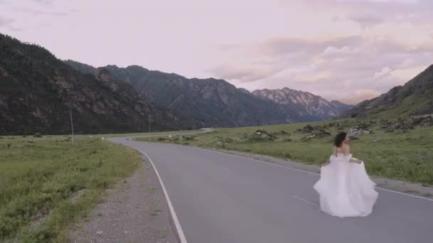 Невеста Свадебном Платье Бежит Дороге Фоне Гор Алтая — стоковое видео