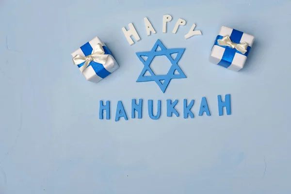 Hanukkah background with Hanukkiah symbol Star of David, wooden letters, gifts. Happy Hanukkah. Flat lay. Blue background — Stock Photo, Image