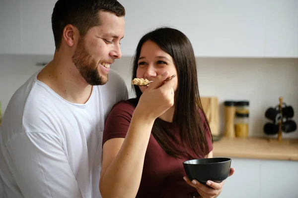 Pareja joven haciendo el desayuno y divirtiéndose Imagen De Stock