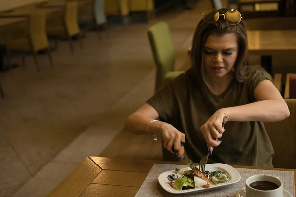 Ung vacker kvinna äter frukost på caféet. Vacker ung kvinna äter frukost med croissant med kyckling, grönsaker och sallad och kaffe på café — Stockfoto