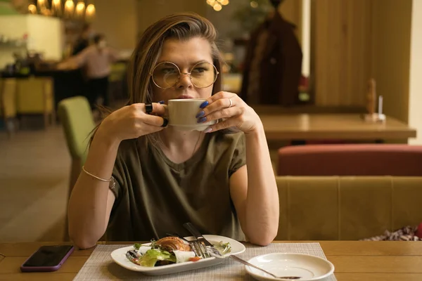 Ung vacker kvinna äter frukost eller lunch på café — Stockfoto