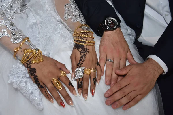新婚夫妇的手和结婚戒指在一起，在皮肤上画着东方母鸡，而不是纹身 — 图库照片