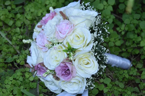 Ramo de novia de boda de rosas blancas y rosas sobre hierba verde — Foto de Stock