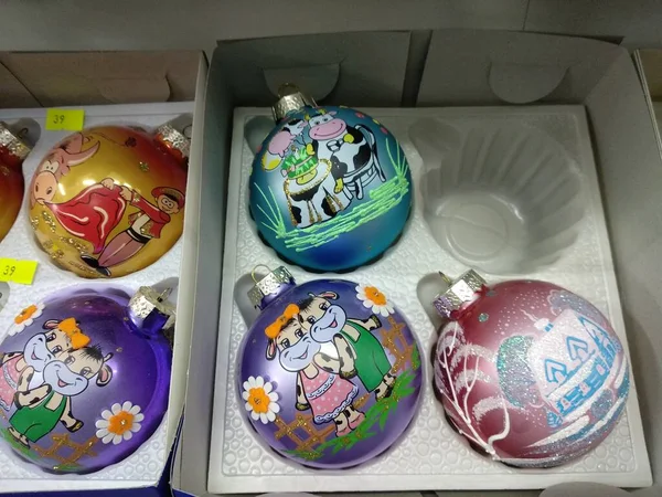 Lembranças de Ano Novo em uma caixa, bolas coloridas redondas em uma árvore de Natal com o símbolo do touro de ano — Fotografia de Stock