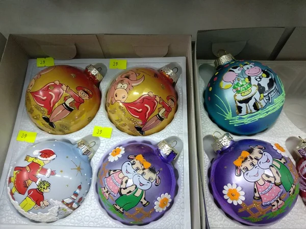 Lembranças de Ano Novo em uma caixa, bolas coloridas redondas em uma árvore de Natal com o símbolo do touro de ano — Fotografia de Stock