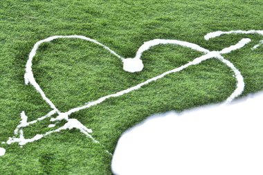 Sevgililer Günü 'nde yeşil çimenlere beyaz köpükle sevgililerin kalp sembolü çizilir. Yüksek kalite fotoğraf