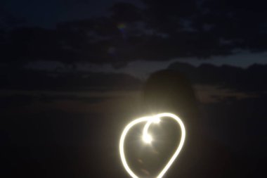 Fener beyaz ışığı çizimi, gece gökyüzünde kalp sembolünün ana hatları. Yüksek kalite fotoğraf